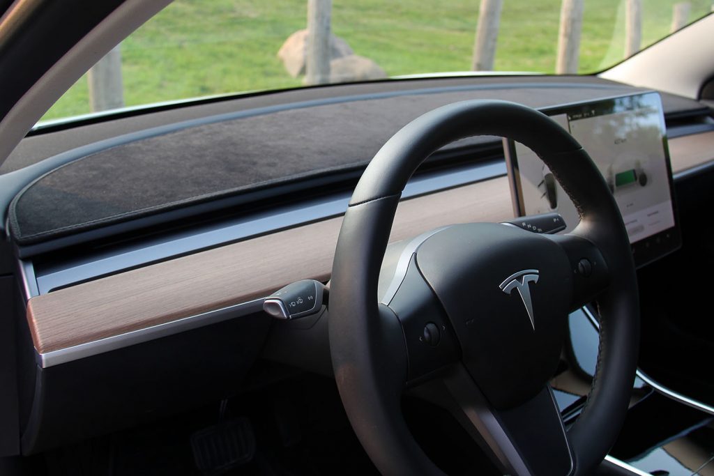 Steering Wheel of a Tesla Model 3 with a Tesloid Anti-Glare Dash Mat