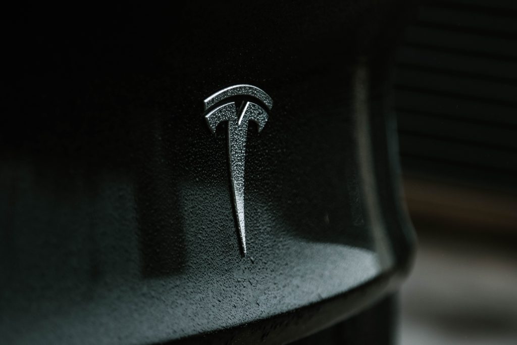 Chrome Tesla Emblem on a Solid Black Model