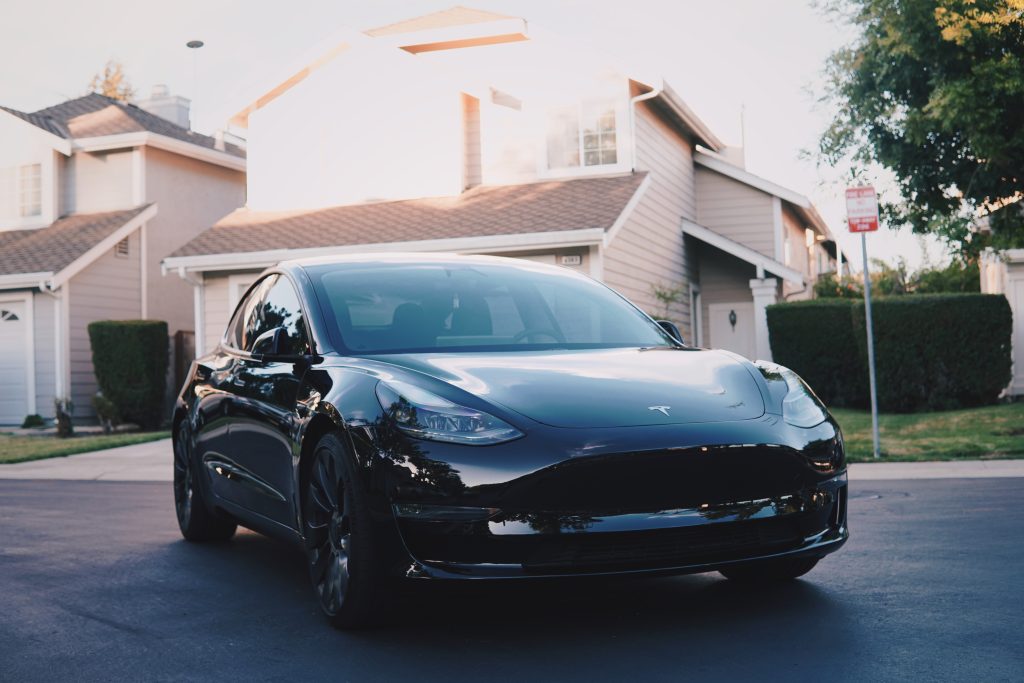 Solid black Tesla Model 3 in a residential neighborhood