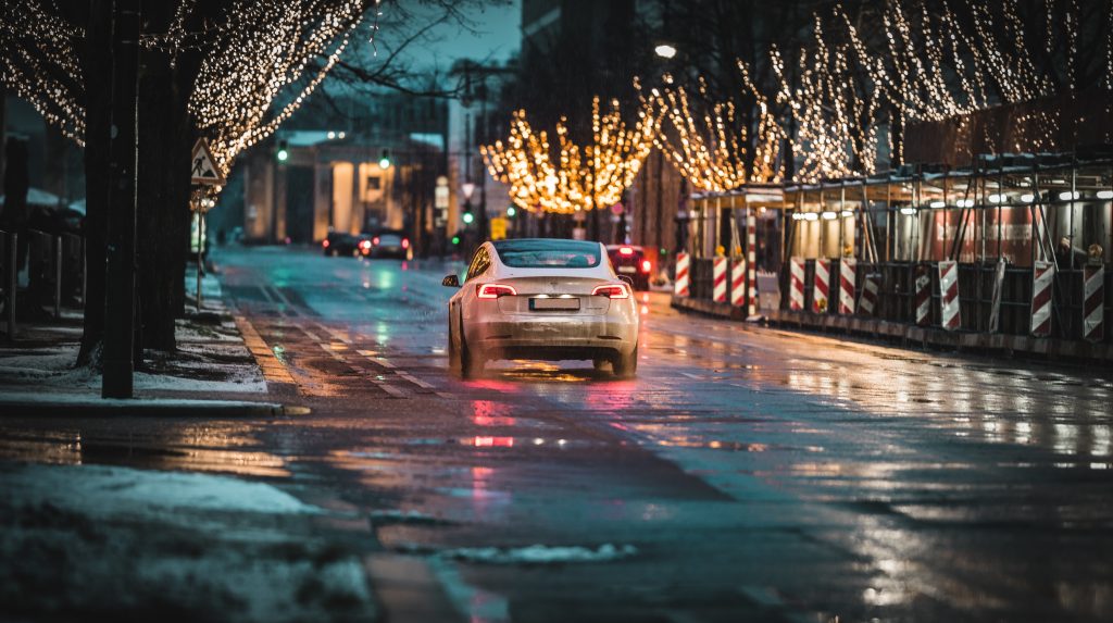 Pearl White Tesla Model 3 Driving in a Cold and Wet Environment